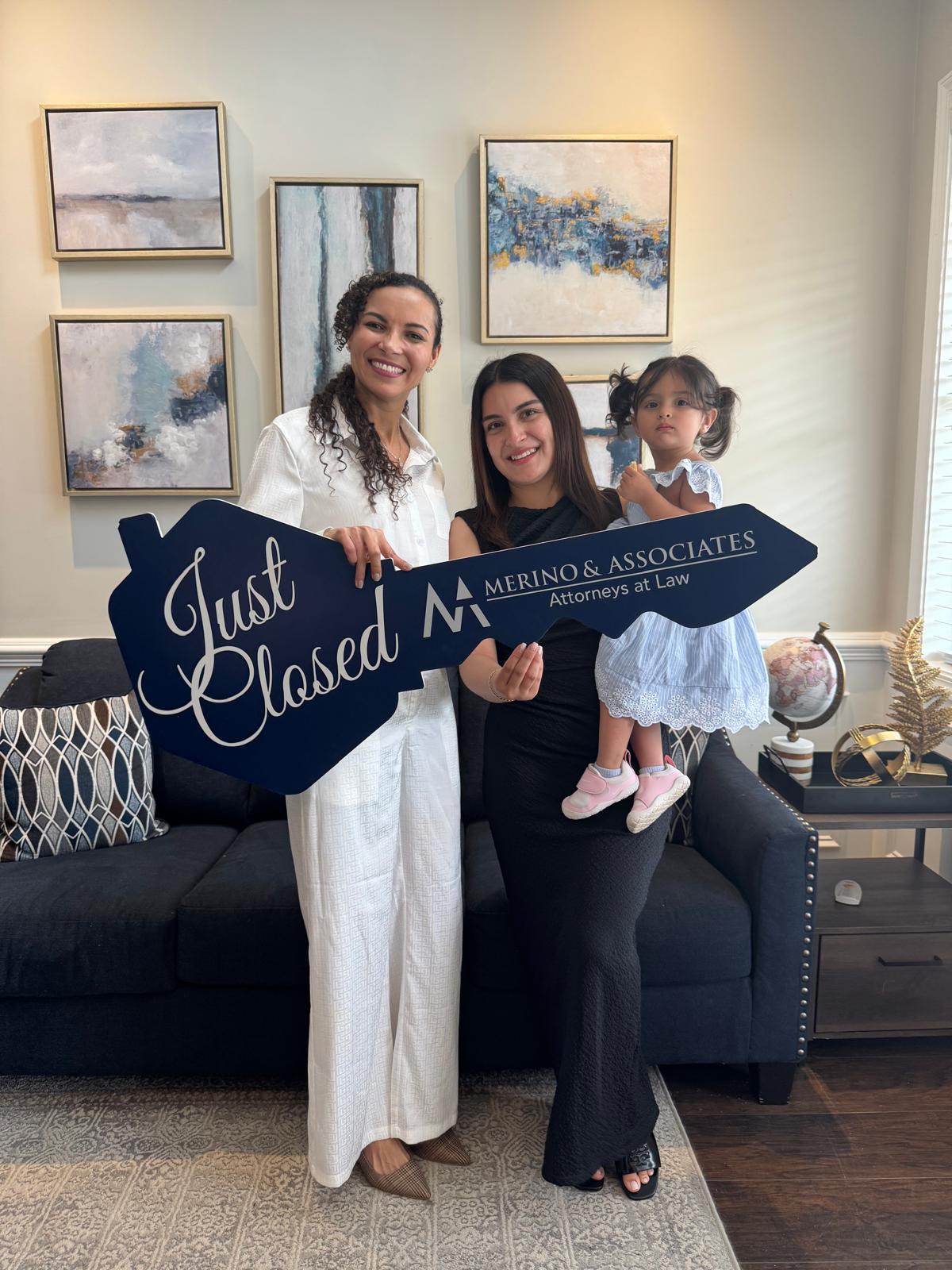 Mamá joven y su hija con la llave de Just Closed en su casa nueva